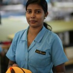 This is one of the smiling workers in the factory. In the photo she's working on a mast sleeve.